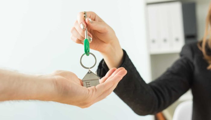Business, realtor and real estate concept - Hand-to-hand key from new home
