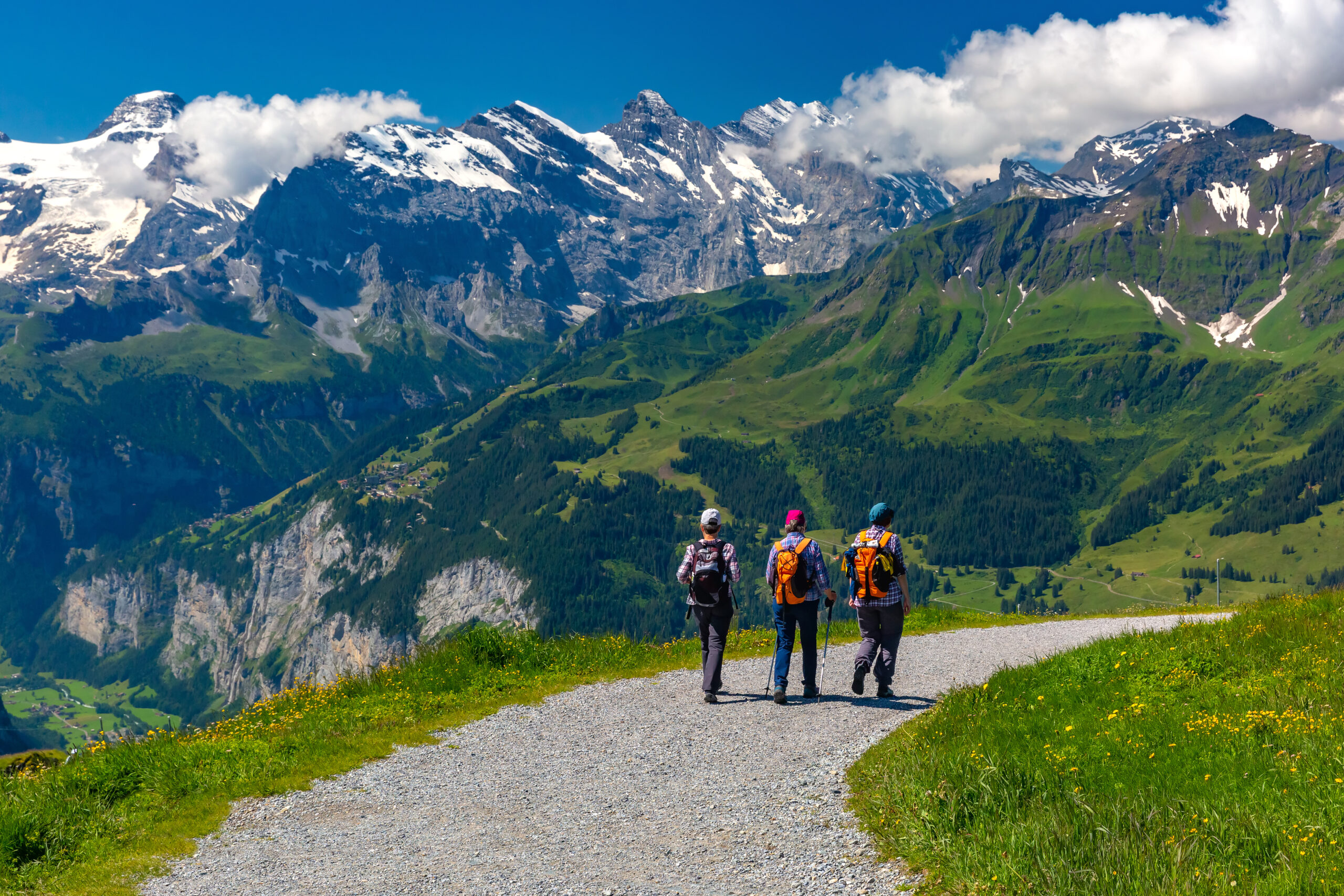 Tourists on hiking trail on mountain Mannlichen, popular viewpoint in Swiss Alps, Switzerland.